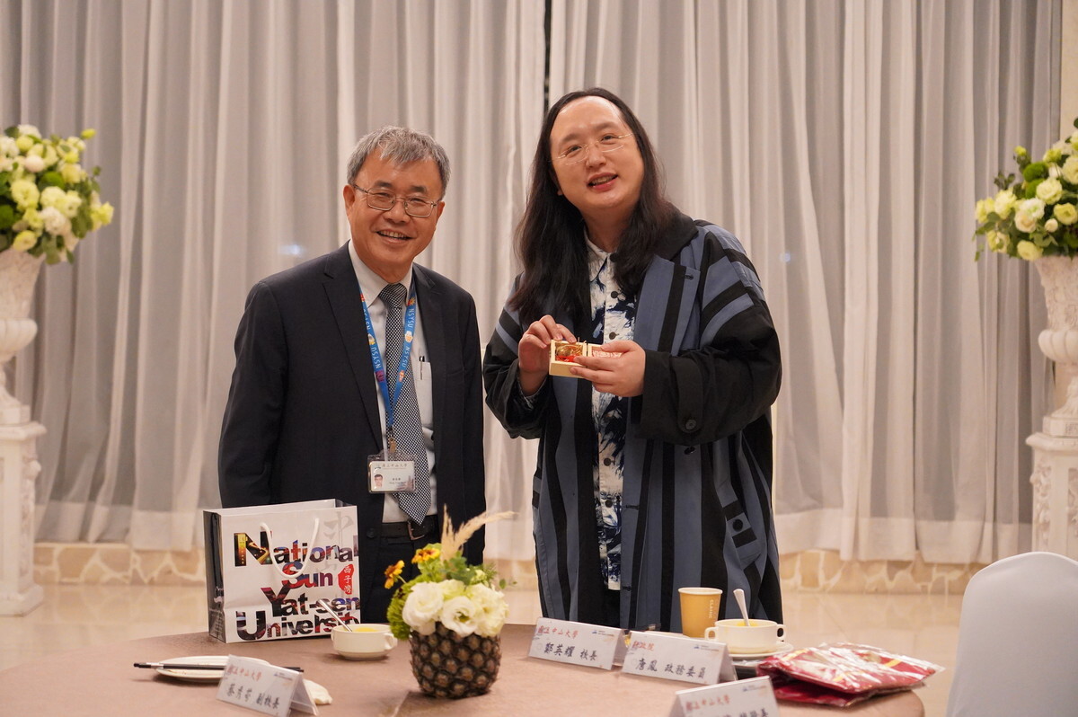 國立中山大學新設社會創新研究所，邀請行政院政務委員唐鳳(右)蒞校分享「台灣社會創新發展趨勢」，校長鄭英耀(左)致贈「牛鈴」紀念品。圖 / 西灣學院提供圖片